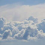 Blue sky with soft, fluffy clouds creating a tranquil and airy atmosphere.
