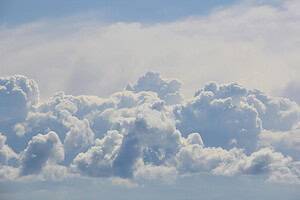 Blue sky with soft, fluffy clouds creating a tranquil and airy atmosphere.