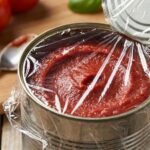 the open canned tomato paste with plastick wrap